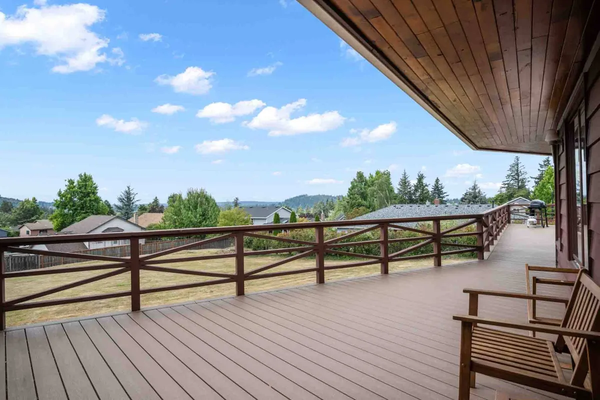 A serene exterior deck scene with a seating area overlooking distant mountains. The view invites relaxation and connection with nature, while the deck provides space for adults to unwind while kids play nearby or for winding down after a busy day of exploration.